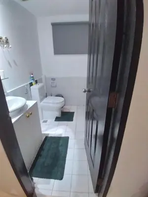 a bathroom with a toilet and a sink and a shower at Executive Studio Apartment in BGC in Manila