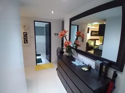 a living room with a large mirror on the wall at Executive Studio Apartment in BGC in Manila