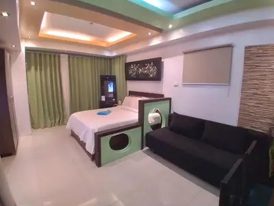 a bedroom with a bed and a couch at Executive Studio Apartment in BGC in Manila