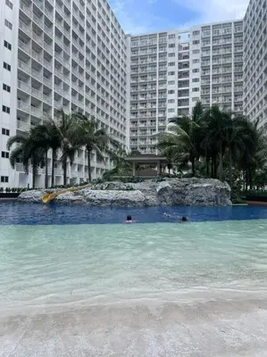 a swimming pool in front of a large building at Shore Residences Tower D - One Bedroom I Good for 6 guests I Walk to Mall of Asia in Manila