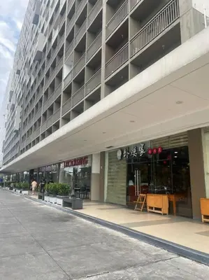 a large building with a store in front of it at Shore Residences Tower D - One Bedroom I Good for 6 guests I Walk to Mall of Asia in Manila