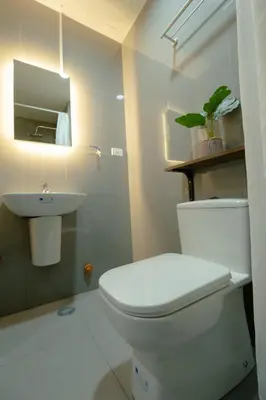 a bathroom with a white toilet and a sink at Modern Living 1 Makati in Manila