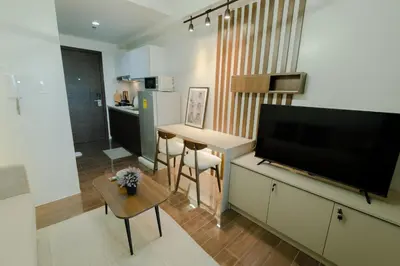 a living room with a flat screen tv and a table at Modern Living 1 Makati in Manila