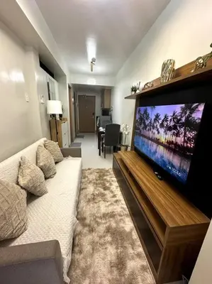 a living room with a large flat screen tv at Ellie's Place Shore 3 T3 in Manila
