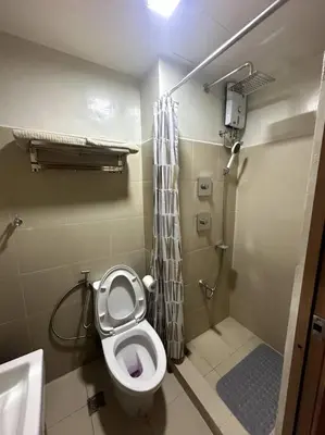 a small bathroom with a toilet and a shower at Ellie's Place Shore 3 T3 in Manila