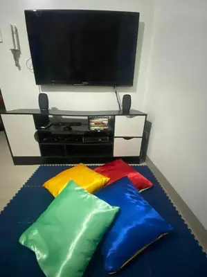 a tv and some colorful pillows in a room at Shore2 Condo 1BR Balcony, Wifi, Pool, MOA, Airport in Manila