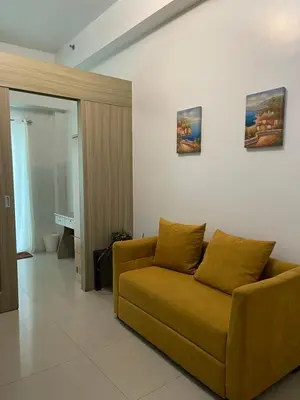 a living room with a brown couch in a room at Shore Residence Direct Pool Access MOA Complex in Manila