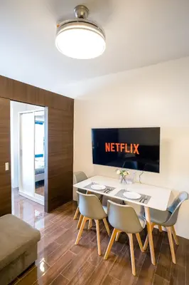 a dining room with a netflix sign on the wall at Modern Living 3 Makati in Manila