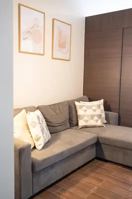 a couch in a living room with two pillows on it at Modern Living 3 Makati in Manila