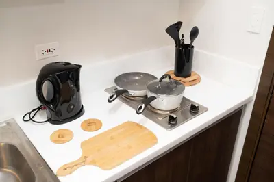 a kitchen counter with two pots and pans on a stove at Modern Living 3 Makati in Manila