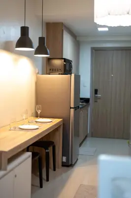 a kitchen with a refrigerator and a table with wine glasses at Modern Living 4 MOA Pasay in Manila