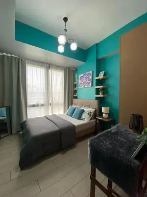 a bedroom with a bed and a blue wall at BGC McKinley Taguig 1BR with Balcony near Venice Grand Canal mall in Manila