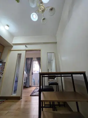 a living room with a ceiling fan and a table at Cozy apartment near Greenbelt Makati City in Manila