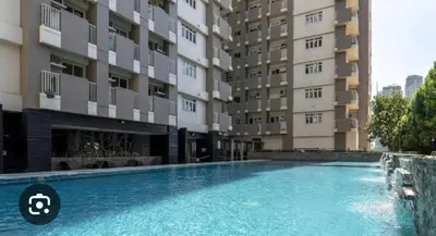 a swimming pool in front of a building at Cozy apartment near Greenbelt Makati City in Manila