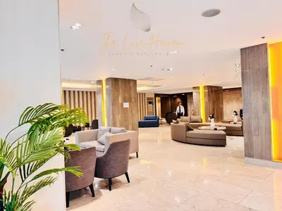 a lobby of a hotel with couches and chairs at The Luxe Haven Shore 3 Residences in Manila