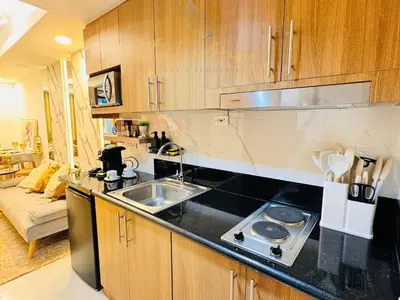 a kitchen with a sink and a stove top oven at The Luxe Haven Shore 3 Residences in Manila