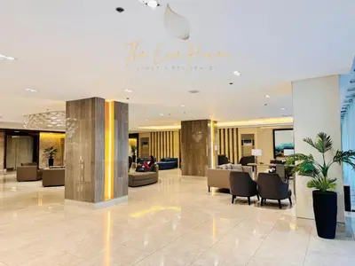 a lobby with couches and chairs in a building at The Luxe Haven Shore 3 Residences in Manila