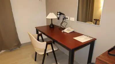 a desk with a lamp and a phone on it at Centennial Inn in Kawit