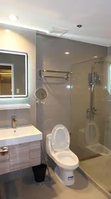 a bathroom with a toilet and a shower and a sink at Centennial Inn in Kawit