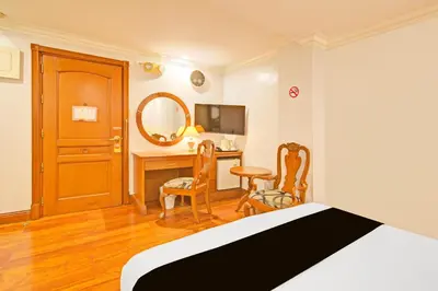 a bedroom with a bed and a desk with a mirror at Townhouse OAK Makati Manila Near PNR Pasay Evangelista formerly VIP Suites in Manila