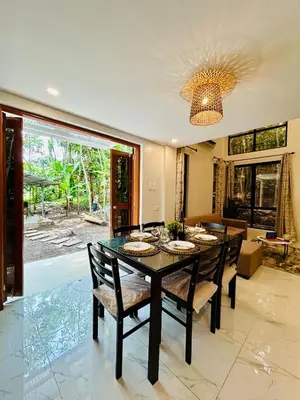 a dining room with a black table and chairs at Tagaytay's Cozy Loft-type Forest House and Camp in Silang