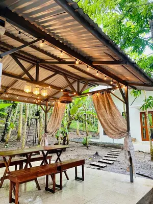 a wooden picnic table under a pavilion at Tagaytay's Cozy Loft-type Forest House and Camp in Silang