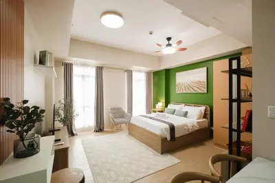 a bedroom with a bed and a green wall at Ocuna Suite - NAIA Manila Airport in Manila