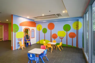 a room with tables and chairs and trees painted on the wall at Ocuna Suite - NAIA Manila Airport in Manila