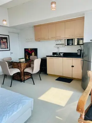 a kitchen with a table and chairs in a room at Spacious 1BR steps to Megamall Ortigas City View in Manila