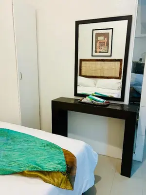 a mirror sitting on a table next to a bed at Spacious 1BR steps to Megamall Ortigas City View in Manila
