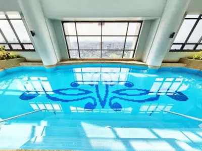 a large swimming pool with blue water in a building at Spacious 1BR steps to Megamall Ortigas City View in Manila