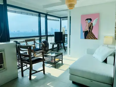 a living room with a couch and a tv at Spacious 1BR steps to Megamall Ortigas City View in Manila