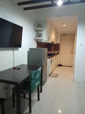 a kitchen with a black table and a kitchen with a refrigerator at Sea Residences Staycation Near Moa Pasay by Jhay in Manila