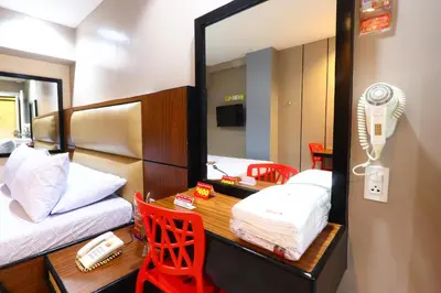 a room with a bed and a desk with a mirror at Hotel Sogo - Pasay Rotonda in Manila