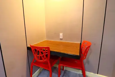 two red chairs around a wooden table in a room at Hotel Sogo - Pasay Rotonda in Manila