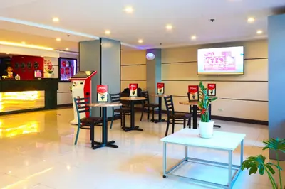a restaurant with tables and chairs and a video game at Hotel Sogo - Pasay Rotonda in Manila