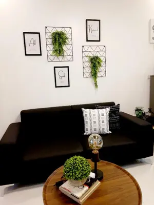 a black couch in a living room with a table at Condo Studio Luxe in Princeton Residences in Manila