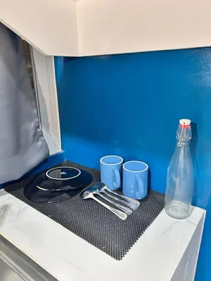a table with two cups and a bottle on a shelf at Origin Studios - Walk to Highstreet, BGC in Manila