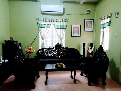 a living room with a piano and a window at USO House in Manggahan