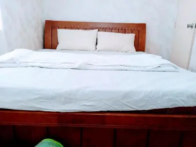 a bed with white sheets and pillows on it at USO House in Manggahan