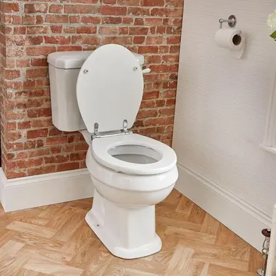 a white toilet in a bathroom with a brick wall at USO House in Manggahan