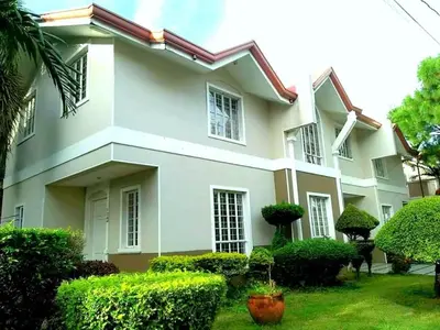 a large white house with bushes in front of it at USO House in Manggahan
