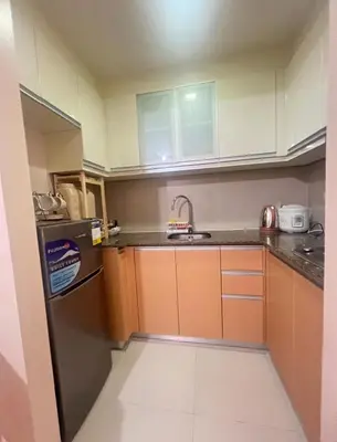 a small kitchen with a sink and a refrigerator at Cozy Condo at Eighty One Newport Blvd across NAIA Terminal 3 in Manila