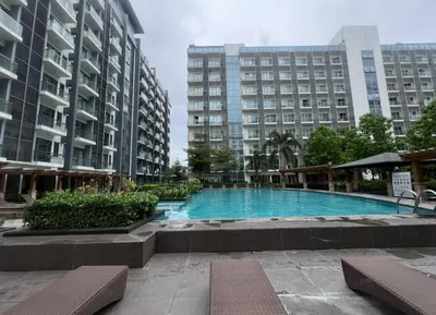 a large swimming pool in front of two tall buildings at Cozy Condo at Eighty One Newport Blvd across NAIA Terminal 3 in Manila