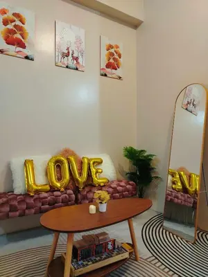 a living room with a couch with a love pillow on it at Cozy Condo at Eighty One Newport Blvd across NAIA Terminal 3 in Manila