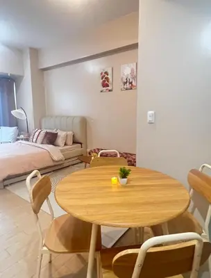 a living room with a table and a bed at Cozy Condo at Eighty One Newport Blvd across NAIA Terminal 3 in Manila