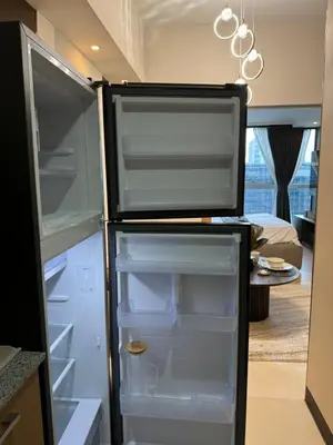 a refrigerator with its door open in a kitchen at Staycations Up Above 17 at BGC in Manila