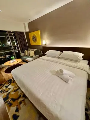 a hotel room with a large bed with a towel on it at Novotel Suites Manila Aqua Residences Near Makati by Hamodi'sCrib in Manila