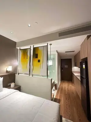 a bedroom with a white bed and a kitchen at Novotel Suites Manila Aqua Residences Near Makati by Hamodi'sCrib in Manila