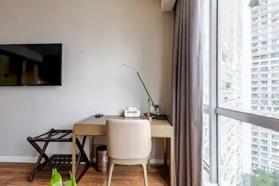 a desk with a chair in a room with a window at Novotel Suites Manila Aqua Residences Near Makati by Hamodi'sCrib in Manila